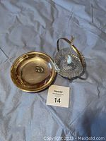 Photo shows a 4-inch silver dish next to a silver stand holding a decorative glass bowl, accompanied by a silver plated spoon lying inside the bowl.