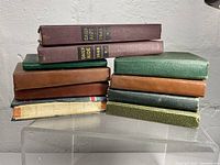 Ten vintage diaries stacked, showing variety of covers and colors, some with dated spines including 1948 and 1945 Daily Aide diaries.