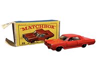 Red Pontiac Coup diecast car with black wheels placed next to original yellow Matchbox box with red branding and car illustration.