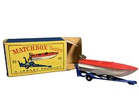 Side view of Matchbox #48 sports boat and trailer beside original box showing branding and colors.