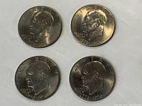 Four Eisenhower Bicentennial dollar coins showing obverse side with Eisenhower profile and date 1776-1976.