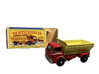 Photo showing Matchbox Lesney #70 grit-spreading truck with yellow grit spreader and red cab, paired with original colorful box featuring truck image and Matchbox branding.