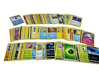 Three rows of assorted Pokémon cards laid out on white background showing a variety of cards and types