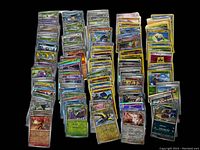 Multiple stacks of sleeved holographic Pokémon cards arranged on a black background