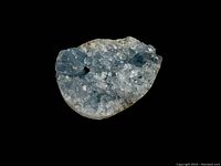 Light blue celestine crystal geode on a black background showing crystal structure and shape.