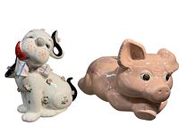 Photo of front view of both piggy banks, showing detailed facial features and patterns.