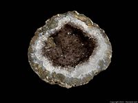 Top view of the smokey topaz geode showing crystal cavity and banded outer layers.