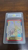 Front view of the 1998 Fleer Michael Jordan 23KT Gold Prism Holo Refractor Signature Series card encased in WCG graded 10 gem mint plastic holder showing holographic gold image and autograph.