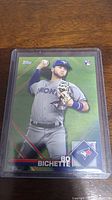 Rookie baseball card of Bo Bichette in clear protective case on wooden surface