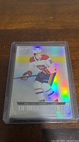 Front view of Cole Caufield rookie hockey card with holographic foil finish and debut details shown clearly.