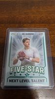 Photo of Joe Burrow rookie football card from 2020 Panini Hit Five-Star Premier Draft series in protective plastic sleeve showing front with 'Next Level Talent' text.