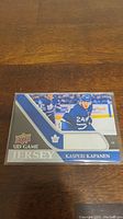 Photo of Kasperi Kapanen hockey jersey trading card by Upper Deck showing player image, team colors, and embedded jersey swatch.
