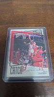 Michael Jordan basketball card featuring an action dunk shot of Jordan in a protective case.
