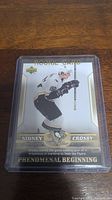 Photo of Sidney Crosby rookie card in protective sleeve showing the front design and details