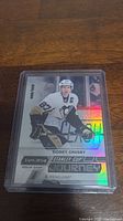 Sidney Crosby hockey card in plastic sleeve showing limited edition 936/999 number, holographic foil design, and player in Penguins uniform.