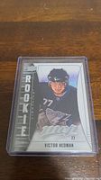 Photo of Victor Hedman rookie hockey card in clear protective casing showing player image, team logo, and rookie label.
