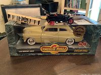 Wide view of 1949 Mercury Coupe diecast model in original box with Wright Flyer and 1927 automobile models on top.