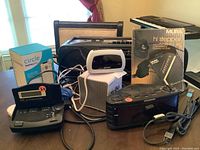 Overview of all electronics items including Sony boom box, Sylvania clock radio, Treo speaker, Mura personal FM/AM receiver, Sharp alarm clock, and Circle Home Plus parental control box.