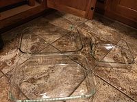 Three Pyrex rectangular glass baking dishes shown on floor