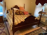 Full view of the Stanley King size bed with bedding and pillows in a bedroom setting.