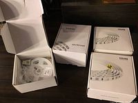 Opened and unopened boxes of various LED strip lights including Ksiize and Govee brands.