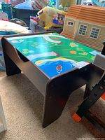 Oblique view of the KidKraft play table with the reversible play surface showing a painted road and water scene for toy cars.
