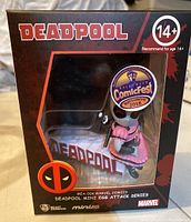Front and side view of Deadpool figure in packaging