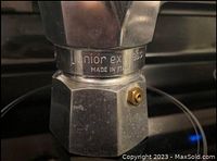 Close-up photo showing Junior Express branding and 'Made in Italy' engraving on the espresso maker's metal body.