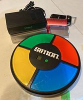 Electronic Simon memory game with four colored buttons and three RF modulators including RadioShack and a generic brand