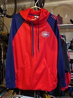 Front view of red and blue Montreal Canadiens hoodie showing logo on chest and front pocket