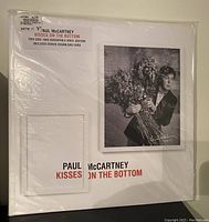 Front cover of Paul McCartney's 'Kisses On The Bottom' vinyl album. Shows album cover art with Paul holding flowers and album title text. Still sealed in shrink wrap with sticker noting details about the edition.