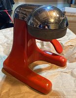Vintage Juice King juicer showing red metal base and chrome dome press with logo.