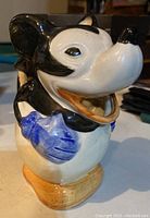 Front and slightly angled view of the ceramic Mickey Mouse jug showing facial details, blue gloves, and tan shoes.