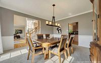 Dining room table and six chairs arranged in dining room space with natural light and wooden floor visible