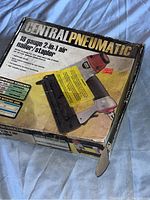 Central Pneumatic product box showing 18 gauge 2-in-1 air nailer/stapler and usage information.