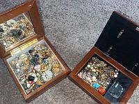 Two wooden music jewelry boxes open to show collections of vintage earrings inside; one box has a mirror lid and the other a photo display with visible music mechanism.