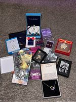 Full view of all jewelry items arranged showing boxes with assorted necklaces, pendants, brooches, earrings, and bracelets in gift packaging.