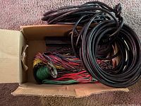 View inside the box showing multiple bundles of colored wiring and coiled cables.