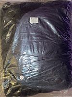 Clear plastic-wrapped black bug net showing folded product inside packaging.