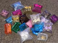 Wide shot showing over 30 assorted colored gift boxes containing jewelry, displayed on carpet.