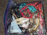 Large Ziploc bag filled with assorted jewelry, visible turquoise and coral beads, metal pieces, and various beads inside.