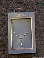 Silver plated necklace with cubic zirconia stones in original packaging labeled 'Believe by Brilliance'.