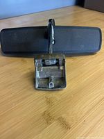 Rear view mirror showing the back side with metal mounting bracket and black frame.
