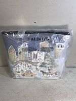 Front view of the Talbots tote bag inside transparent packaging showing winter Central Park scene print with city skyline, ice skating, horse carriage, and NYC taxi.