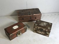 Photo displaying all three wooden boxes together showing overall size and shape differences; includes the small dovetail animal box and two Asian motif jewelry boxes