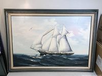 Full view of the framed painting showing the sailing tall ship on the ocean.