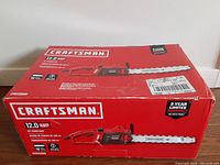 Closed red box featuring the CRAFTSMAN brand, model CMECS600, 12.0 amp, 16-inch chainsaw specifications and branding.