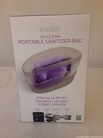 Box front showing Homedics UV-CLEAN Portable Sanitizer Bag branding and claims about killing 99.9% bacteria and viruses in 1 minute.