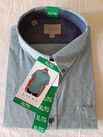 Folded light blue JACHS short sleeve shirt showing collar, tags and button details.