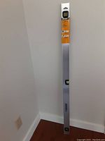 Full view of Johnson 48-inch aluminum level leaning against wall showing length and structure